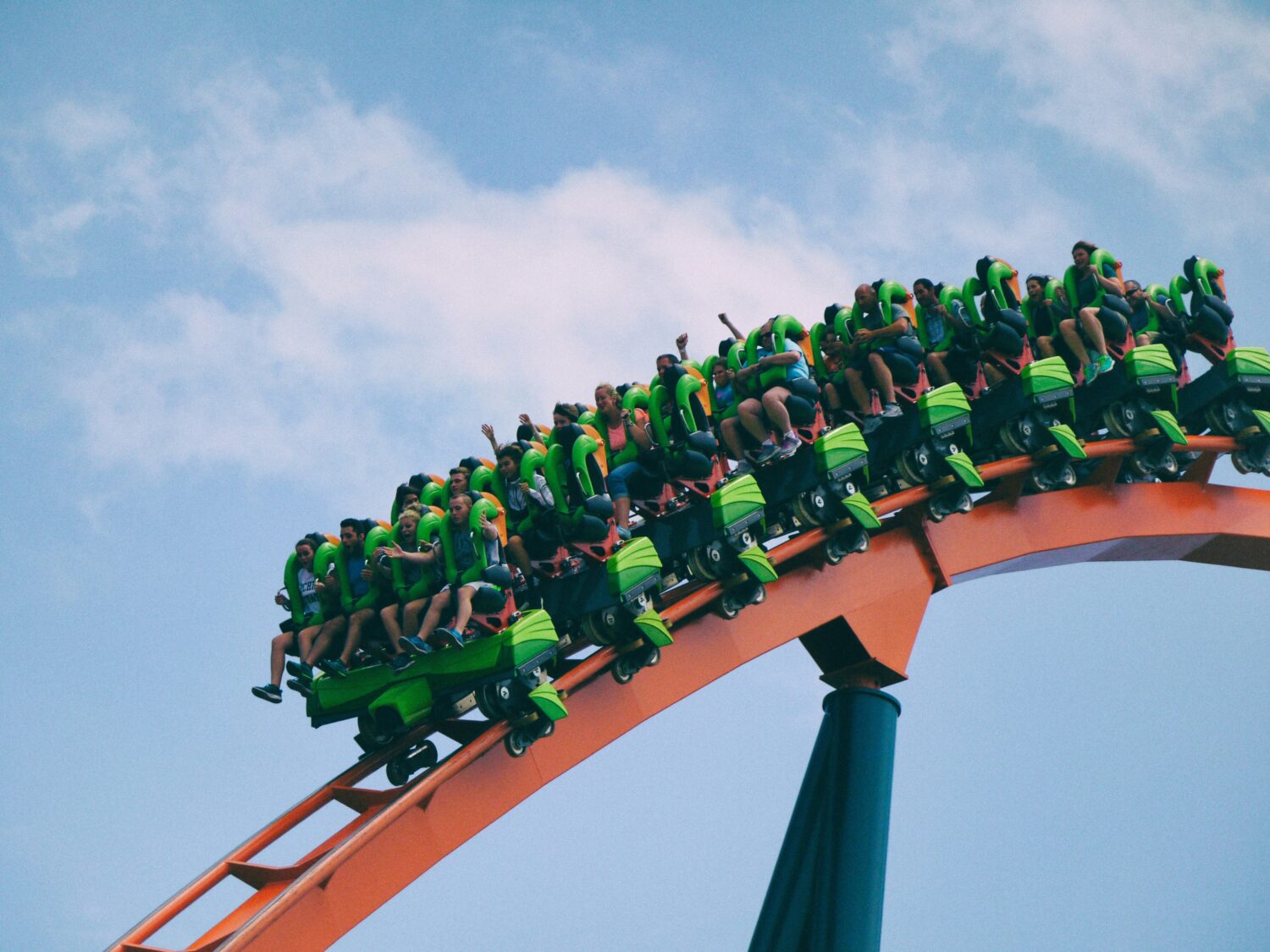 Foto von vielen Leuten die auf einer Achterbahn fahren.