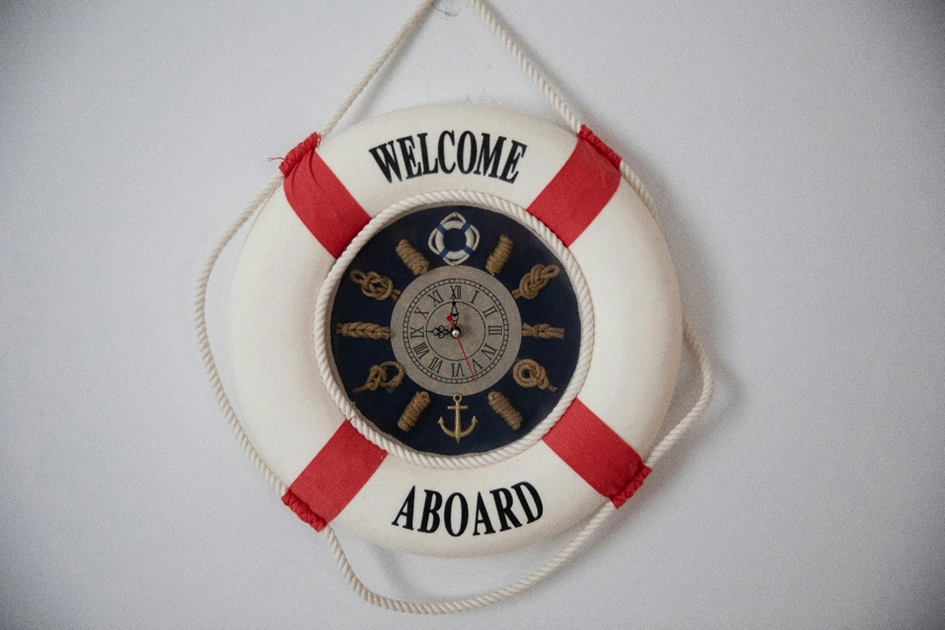 Ein Rettungsring hängt an einer weißen Wand. In ihm beffindet sich ein Kompass, der auch im digitalen Onboarding wichtig ist.