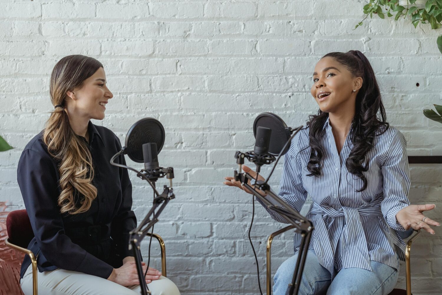HR-Podcasts werden in dem Bilder durch zwei Frauen sitzend vor Mikrofonen dargestellt, die einen Podcast aufnehmen.