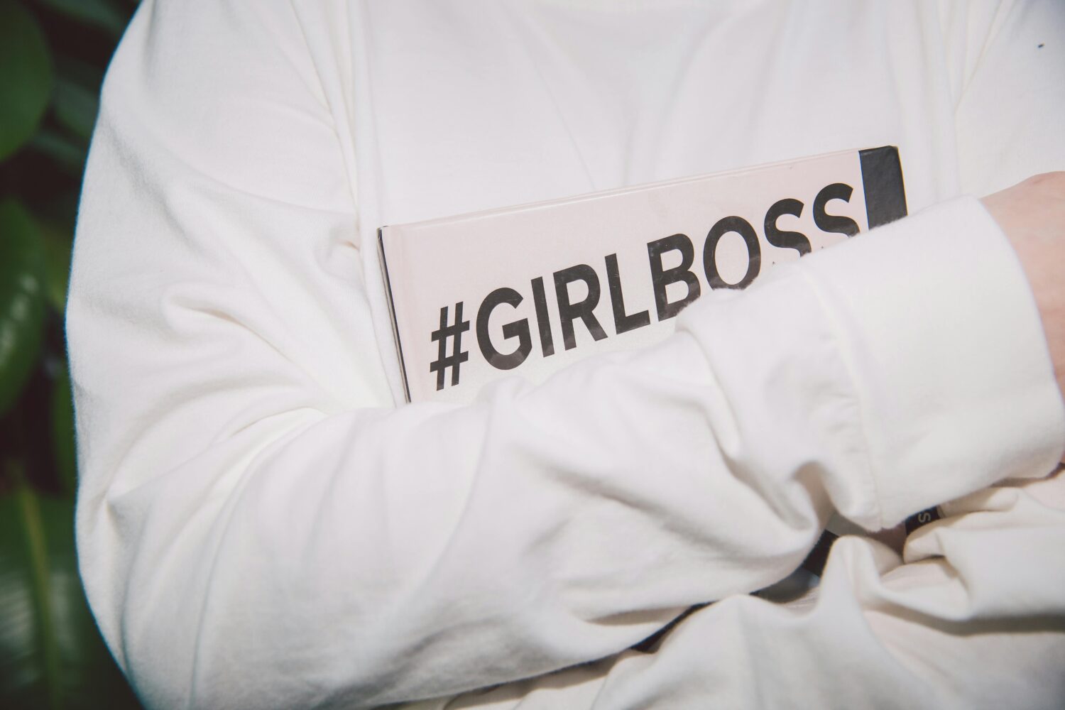 Jemand hält ein Schild in den Armen wo draufsteht #girlboss, was Geschlechterklischees symbolisieren soll.