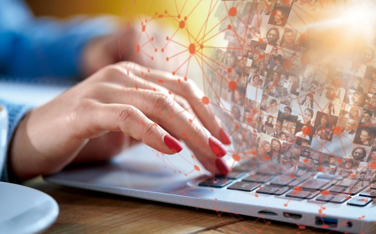 Eine Frau tippt auf einen Laptop. Dabei sieht man vernetzte Bilder, die KPIs zur Talentacquisition darstellen.