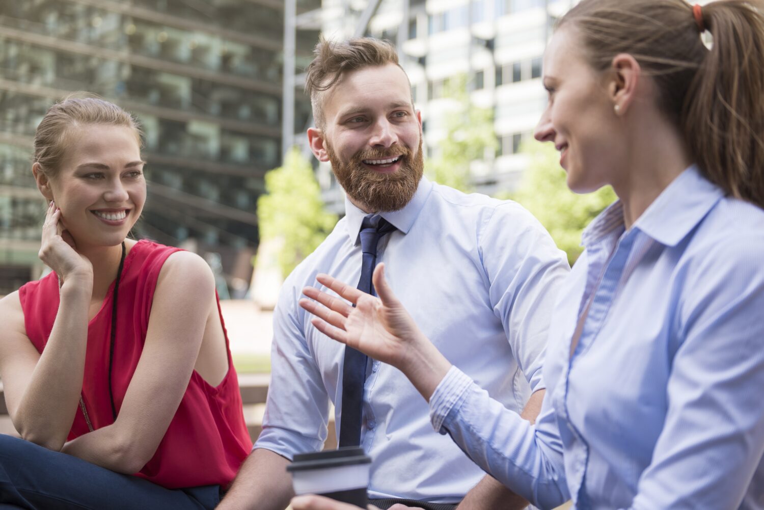 3 Menschen unterhalten sich, links und rechts sitzen jeweils Frauen und in der Mitte ein Mann
